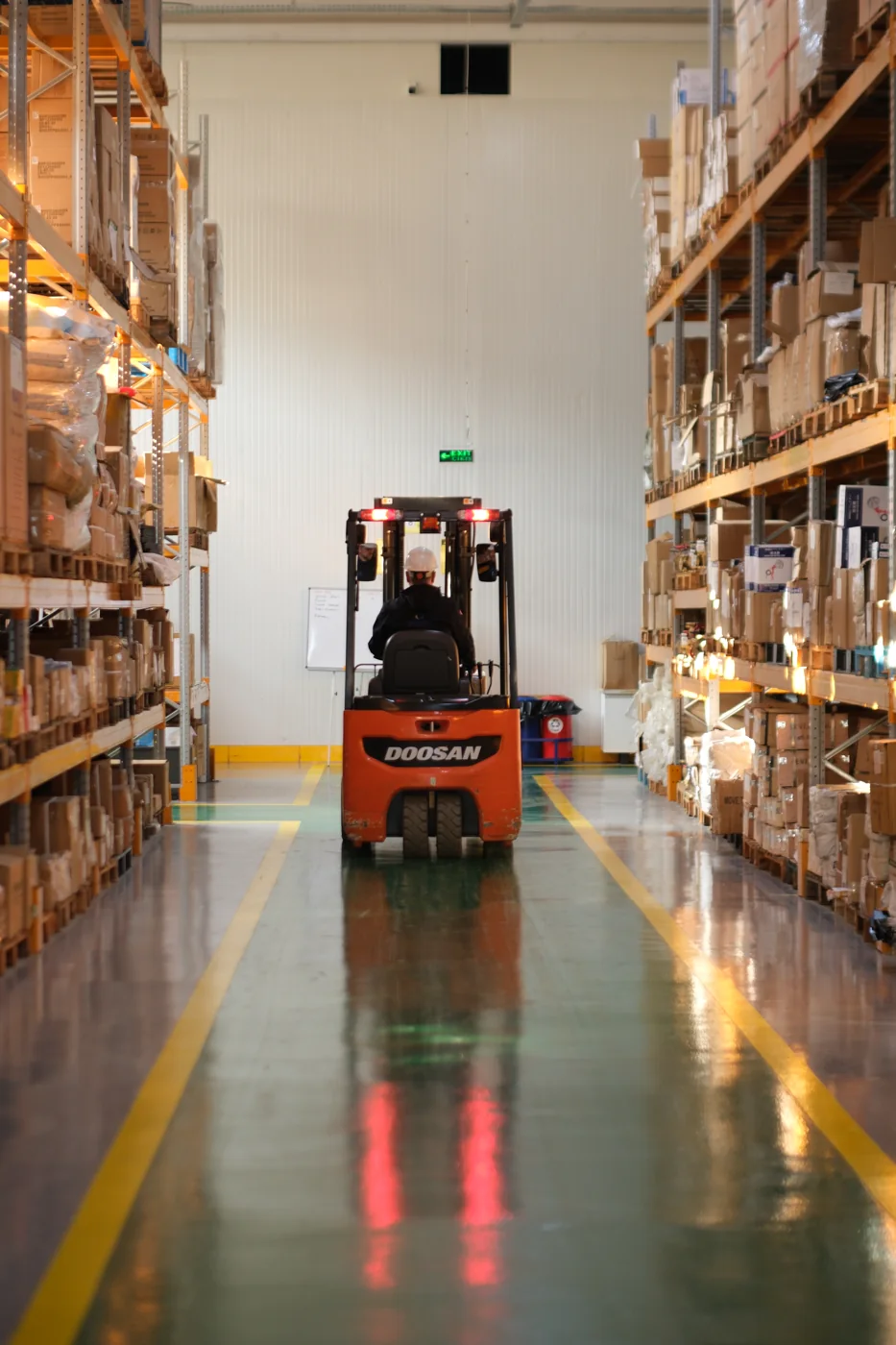 Şimşekler deposunda raflar arasında çalışan forklift